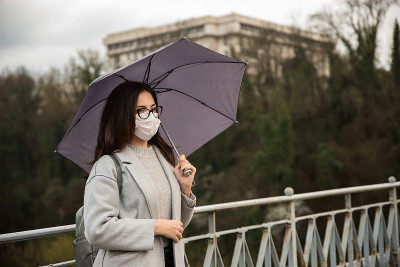 在城市里戴着防护面具的年轻女子