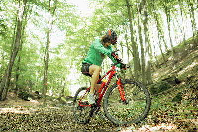 Mountain Bike cyclist woman riding bike at forest.