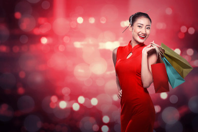 中国妇女穿着旗袍拿着购物袋