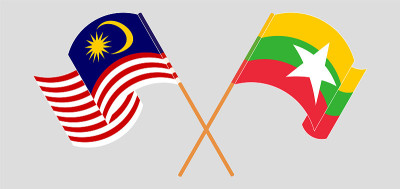 Crossed and waving flags of Malaysia and Myanmar