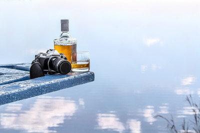 湖边的瓶装龙舌兰酒和平底玻璃杯