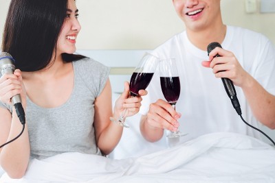 亚洲夫妇在家里一起唱歌。