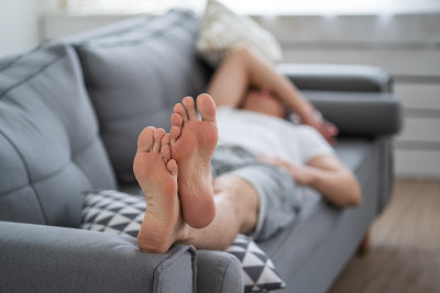 男人累了下班回家休息，男人有脚部、身体护理理念