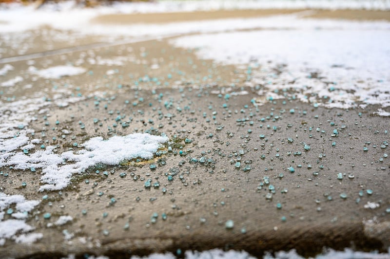 地面上的岩石盐冰融化与雪的特写视图