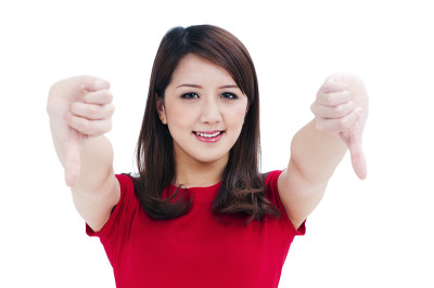 可爱的年轻女子给拇指向下的手势