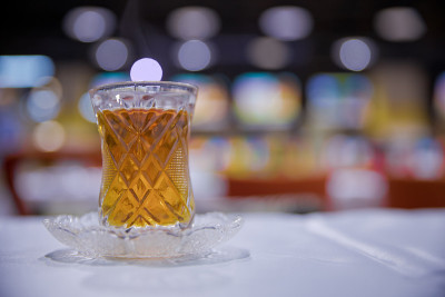 阿塞拜疆传统armudu茶梨形玻璃杯。阿塞拜疆红茶与复古的白色桌子。土耳其黑茶梨形杯，阿塞拜疆传统芳