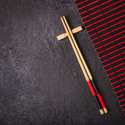 竹筷子和红黑席子。亚洲日本餐桌设置