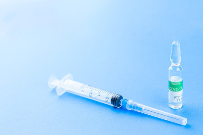 冠状病毒Covid-19疫苗概念，蓝色背景注射器