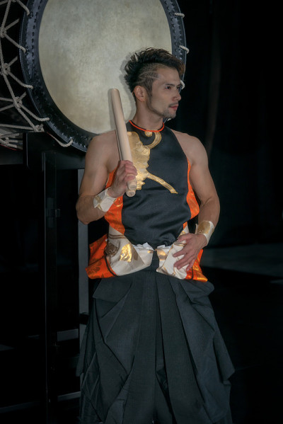 Taiko鼓手站在黑色背景的大鼓前