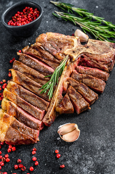 烤牛排。tbone煮牛肉。黑色背景。俯视图