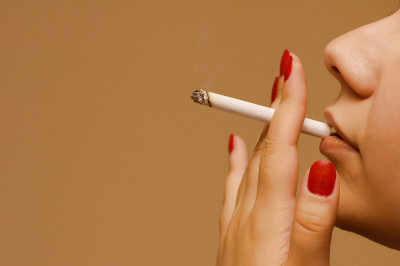 女人在橙色的背景上抽烟