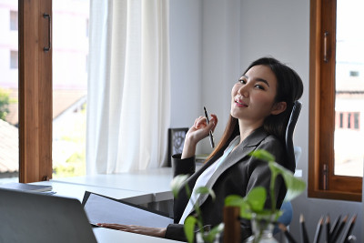 积极的女商人放松在舒适的办公椅上。
