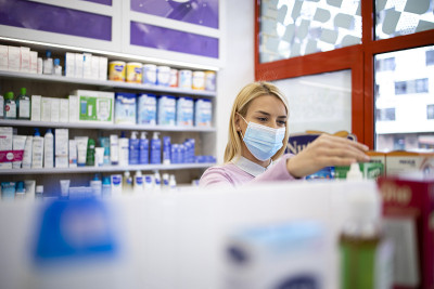 顾客戴着防护口罩在药店购物。