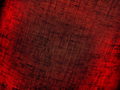 红色抽象背景织物。宏观的形象。用黑影和小图案编织出丝锥色的坑。圣诞节，新年，情人节的背景。