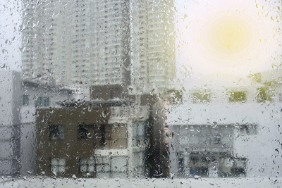 雨点落在城市背景的窗户上