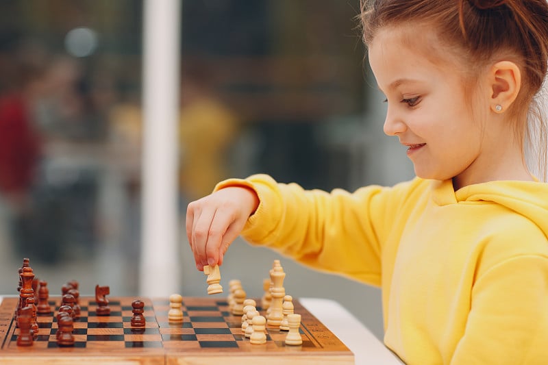 在幼儿园或小学下棋的小孩