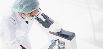 在医学实验室看显微镜的女性医学研究员。医学实验的概念