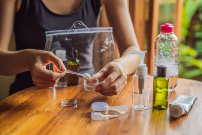 在飞机上运送化妆品的旅行包。化妆品可以倒进小瓶子里了。一位女士把随身携带的化妆品换了一下