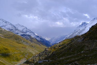 美丽的景色覆盖着绿色的山脉和白雪覆盖的山峰之间的河流和蜿蜒的道路。