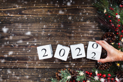 女人的手将2021年的木制日历翻转到2022年
