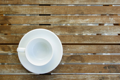 木桌上的陶瓷盘子上放着空茶杯