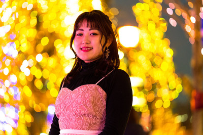 年轻女子站在灯光背景下