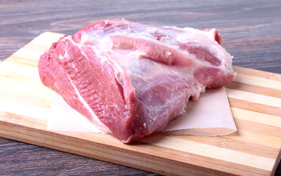 生猪肉排放在木板上，配上香草、大蒜和香料准备烹调。有选择性的重点。