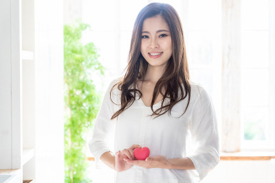 有吸引力的亚洲女人持有心的象征