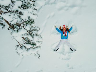 冬天。那个女人躺在森林的白雪中。鸟瞰图。