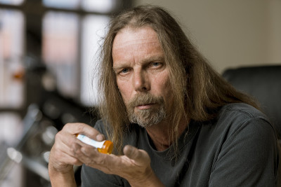 拿着阿片类处方药药瓶的男人