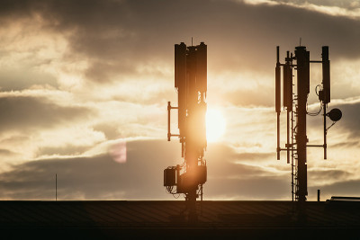 5g和通信塔:屋顶上通信塔的剪影，傍晚