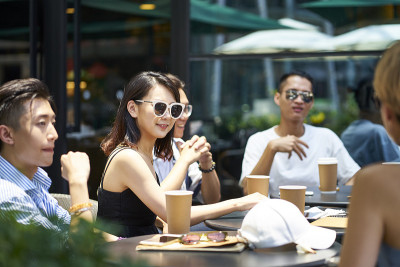 年轻的亚洲成年人在户外咖啡店放松
