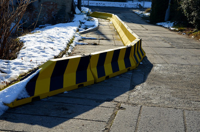 混凝土临时交通标志。公路上的混凝土路障。当一段路滑下时，车辆就被引到一条车道上。车辆碰撞车道分隔。板