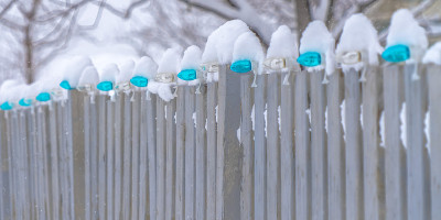 黎明时分，雪白的篱笆上排列着灯泡