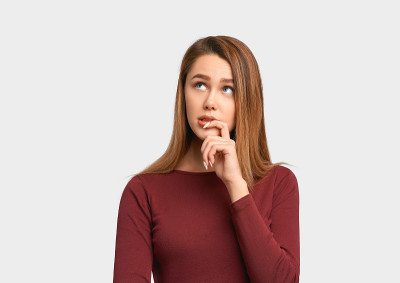 女孩带着兴趣看着旁边，手放在嘴唇附近