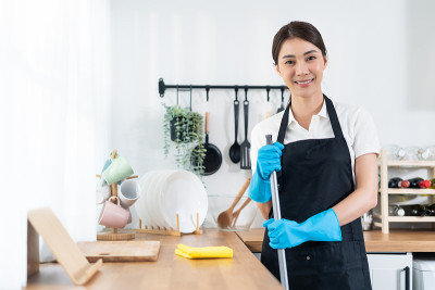 亚洲年轻清洁服务女工在房子工作的肖像。美丽的女孩主妇管家清洁工戴着防护手套微笑着，在做家务或杂务后看