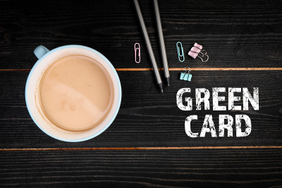 绿卡。黑色办公桌上的咖啡杯