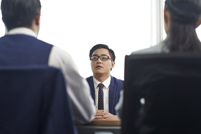 两位人力资源主管面试了一位年轻的亚洲商人