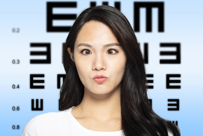 有视力测试表背景的年轻女性