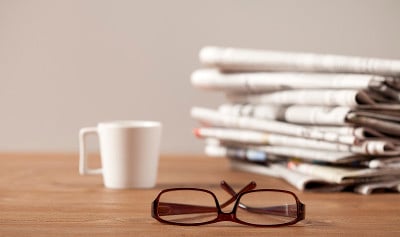 报纸、咖啡杯和眼镜放在桌子上