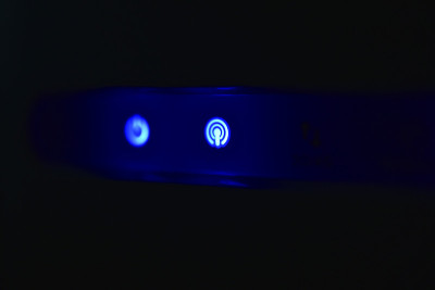 在黑暗中Wi - Fi路由器的蓝色led灯