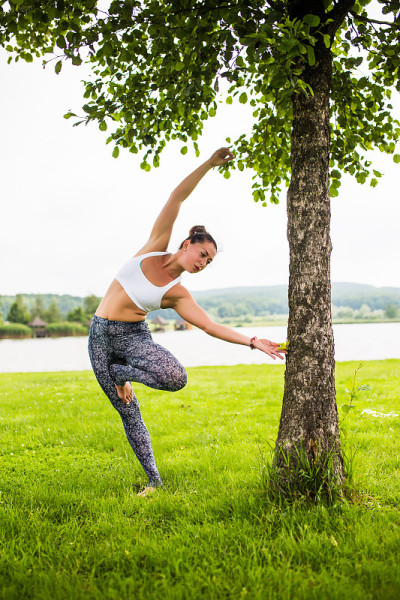 vrikshasana。瑜伽女孩训练户外自然背景。瑜伽的概念。