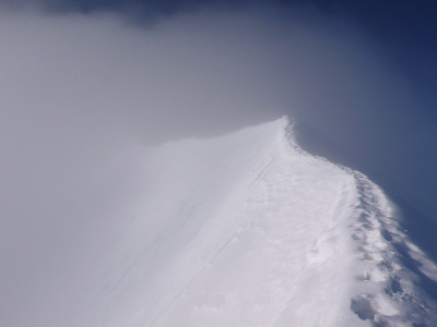 狭窄的雪峰在雾中升起，通向山顶