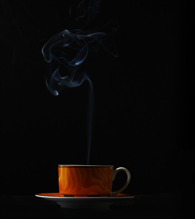 在黑色背景上热气腾腾的咖啡杯