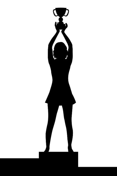 在领奖台上，手持冠军奖杯的女子剪影