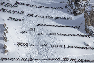 法国Tignes的一个滑雪坡道上，雪地上有雪崩路障和滑雪轨迹。