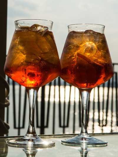 侍者准备了Aperol Sprits夏季鸡尾酒Aperol, prosecco，冰块和橙子在葡萄酒杯
