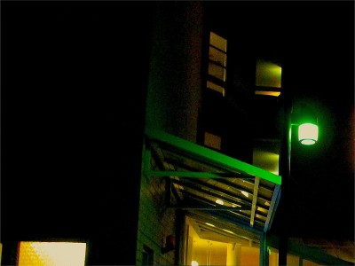 夜现代住宅建筑暖窗照明与绿色门廊灯