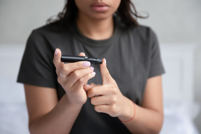 女人拿着血糖仪装置做血糖检测特写