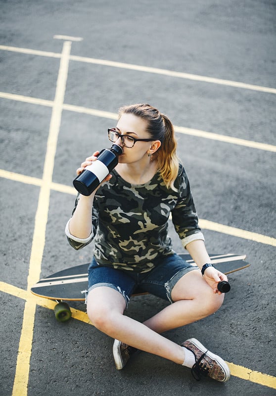 女孩喝瓶子里的水